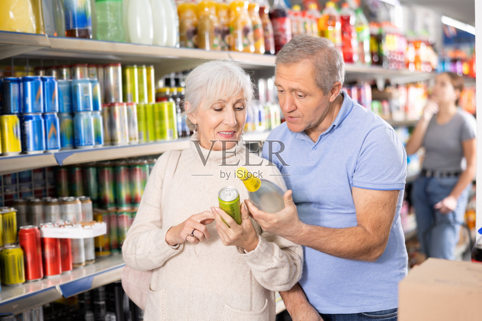 老年妇女和男子在杂货店选择软饮料照片摄影图片