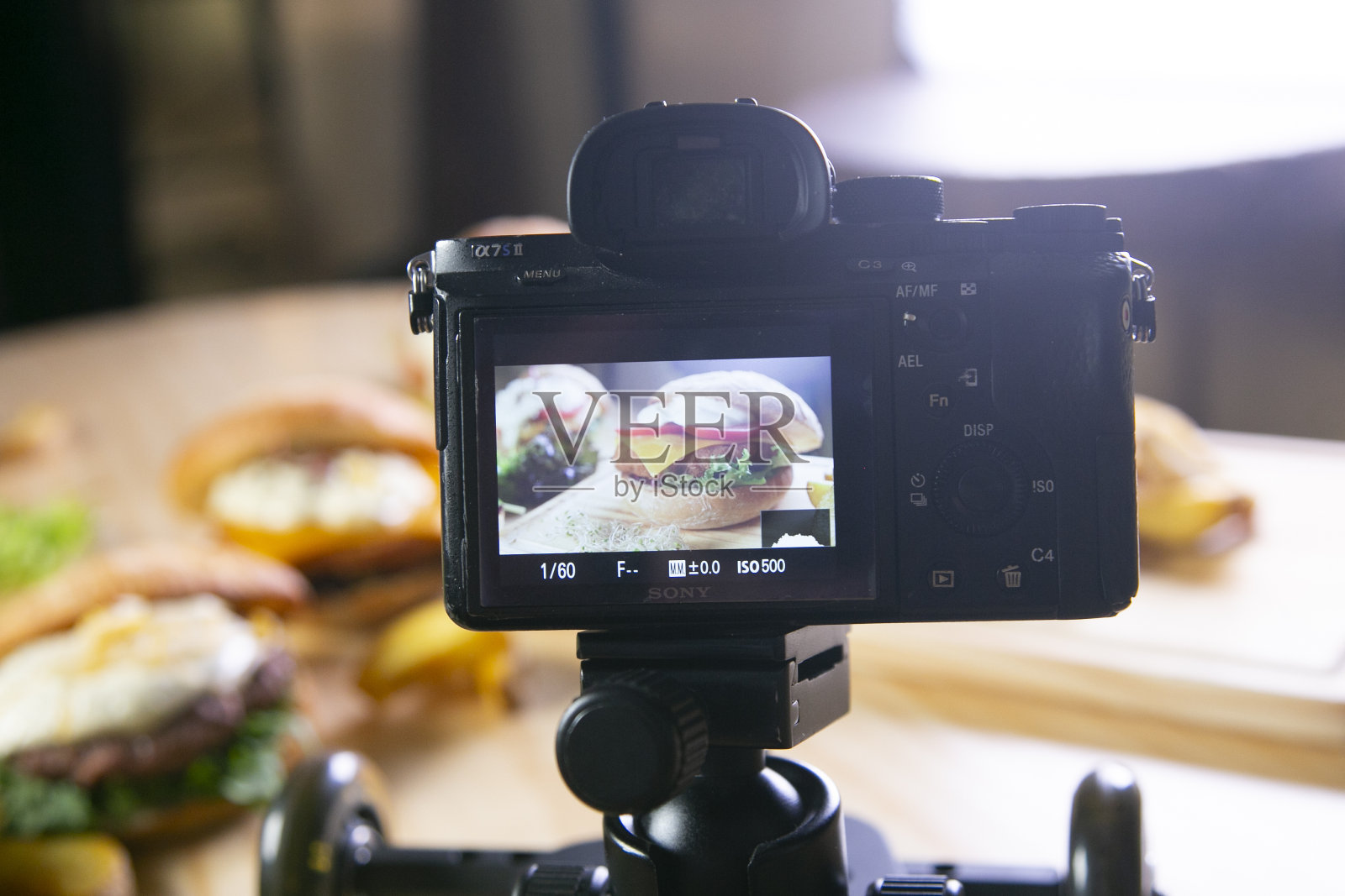 一个人正在用相机拍摄桌子上的食物和饮料。照片摄影图片