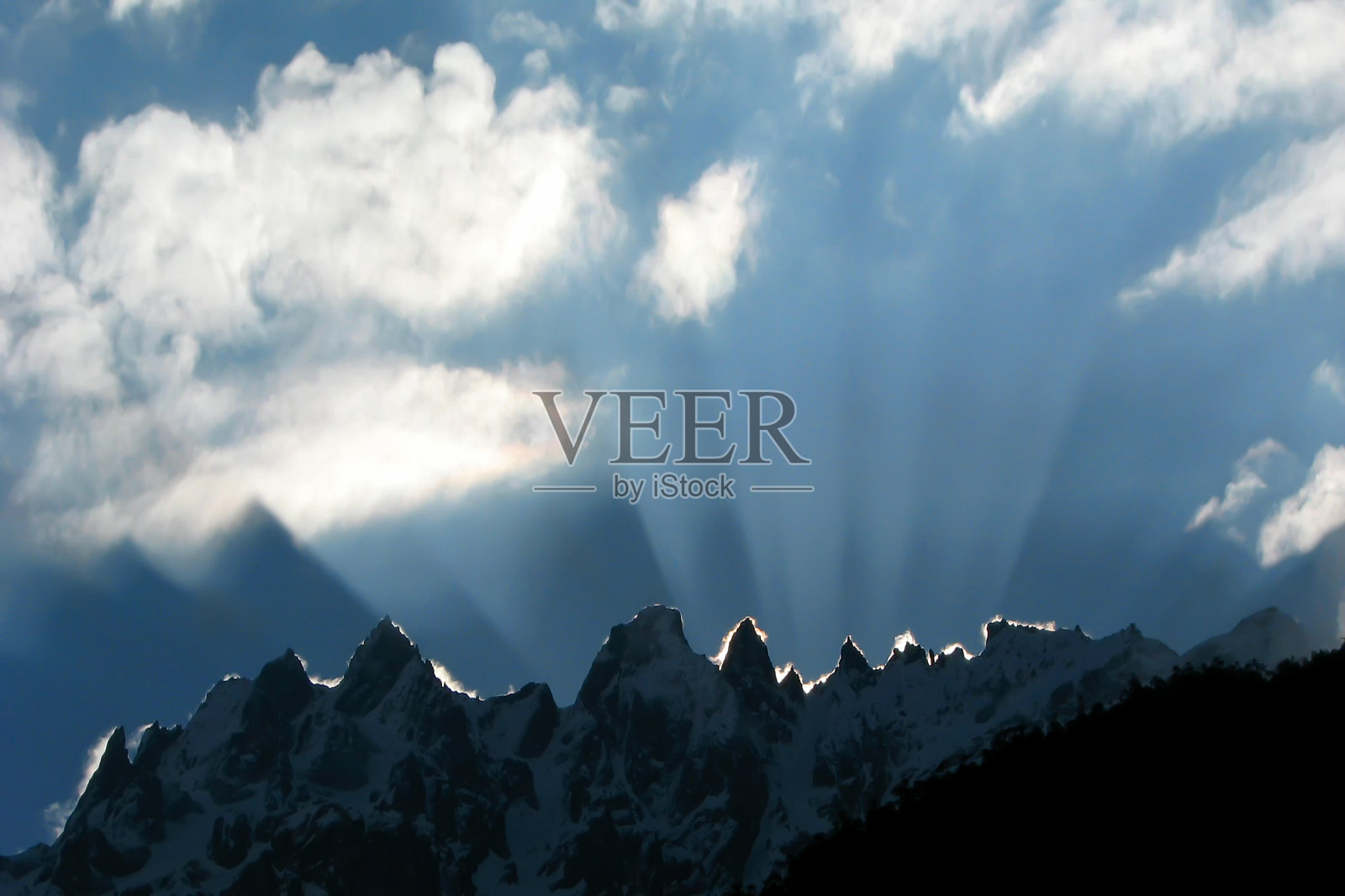 壮观的日出伴随着天空中的白云，阳光切断了喜马拉雅山脉的雪峰。拍摄于印度锡金的拉中。照片摄影图片