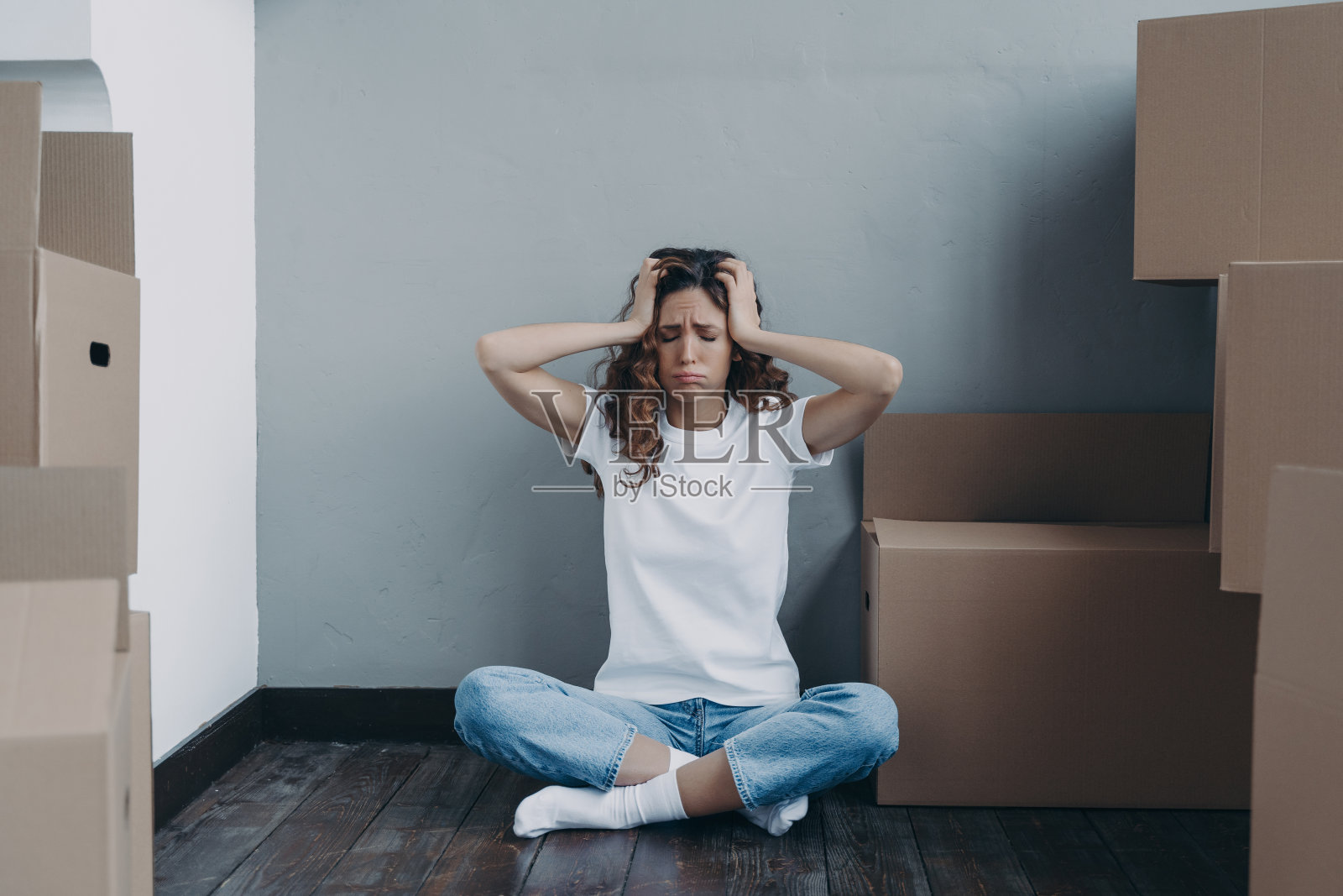 西班牙妇女包装纸箱。房主正在失去她的财产。抵押欺诈的概念。照片摄影图片