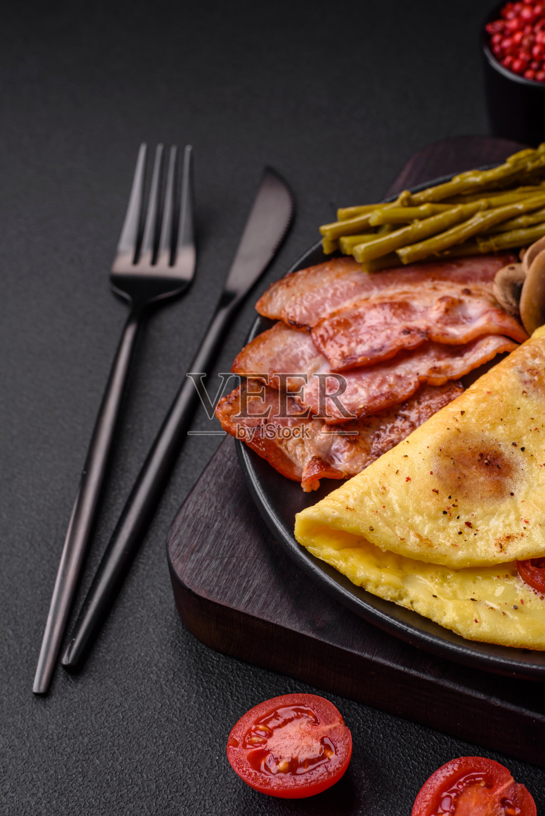 新鲜美味的煎蛋卷配圣女果、培根、芦笋和香料照片摄影图片