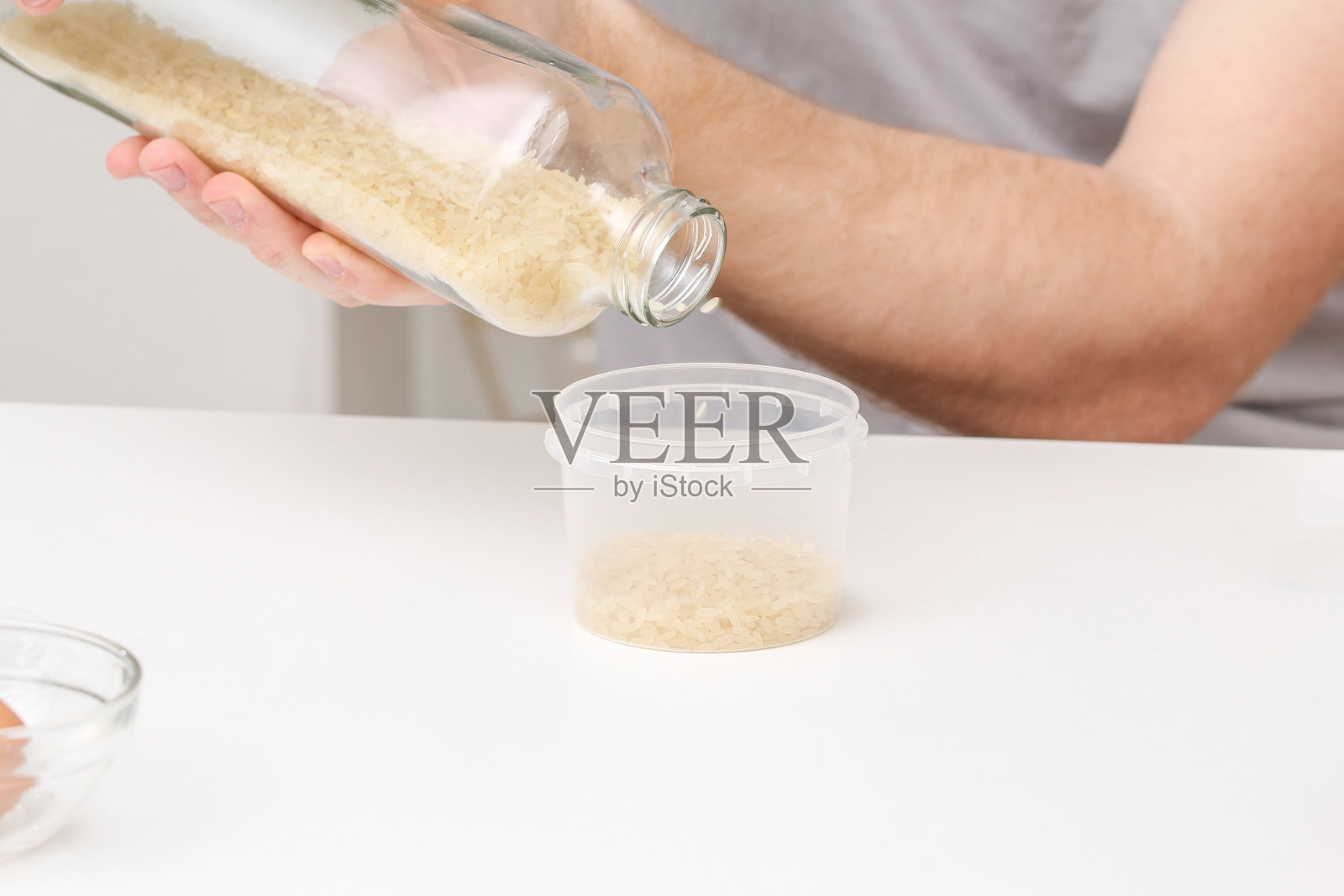 一名男子将大米倒入容器中。一种不同寻常的复活节彩蛋着色和装饰方式。照片摄影图片