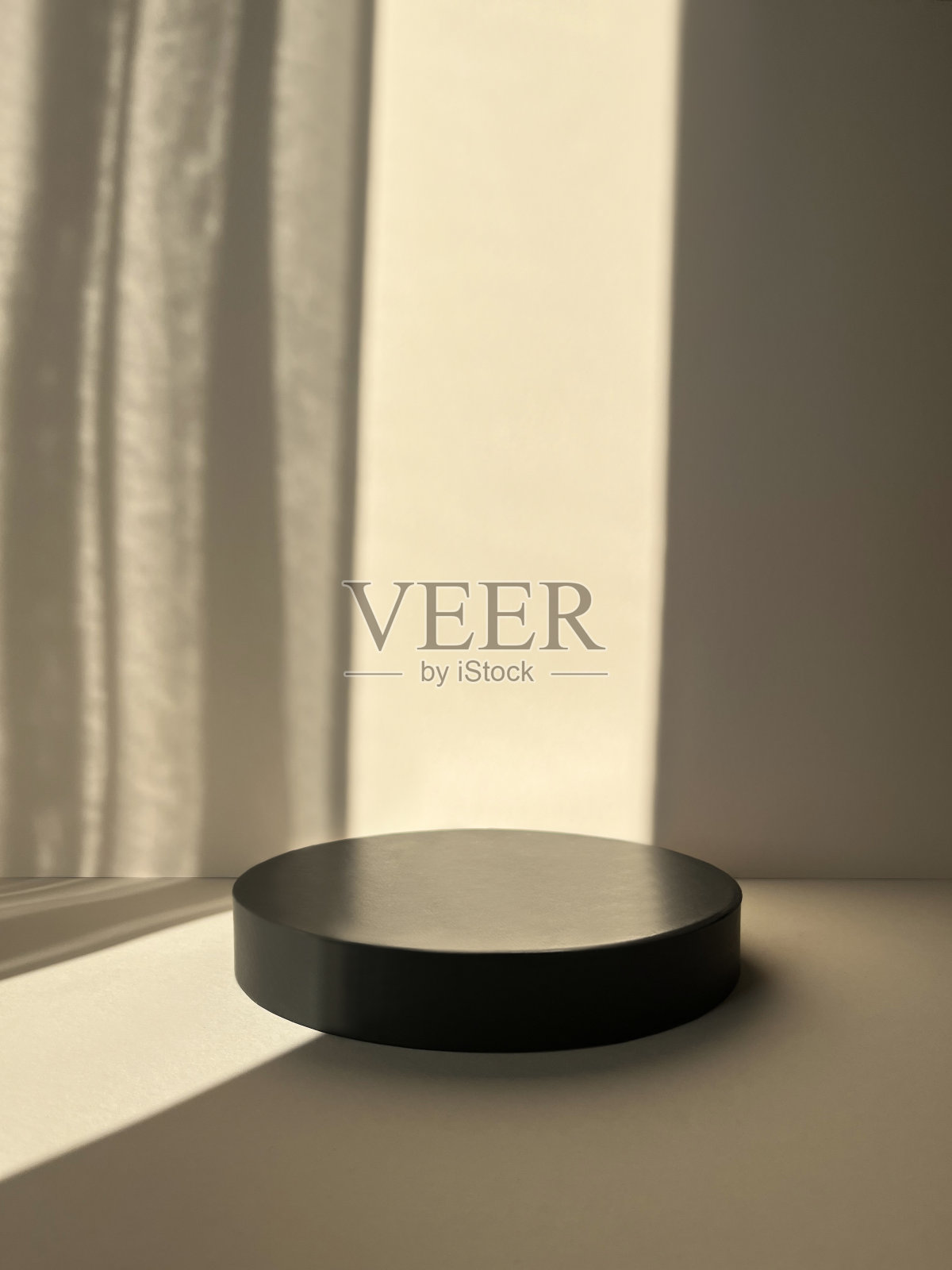 圆形讲台上的米色背景和阴影。产品推广。正面视图，工作室摄影。照片摄影图片