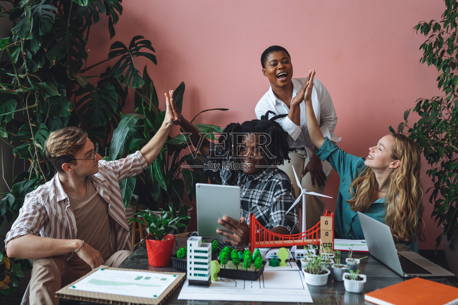 国际多元化的学生群体致力于现代城市建筑项目，使用可再生绿色能源，替代电力，废物回收。头脑风暴，商业计划照片摄影图片