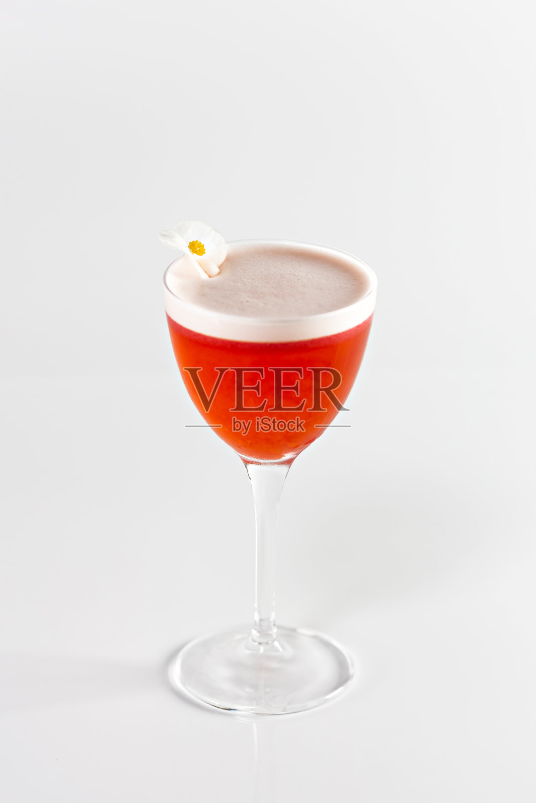 玻璃杯搭配白色背景的红浆果鸡尾酒。饮料是用花装饰的。照片摄影图片