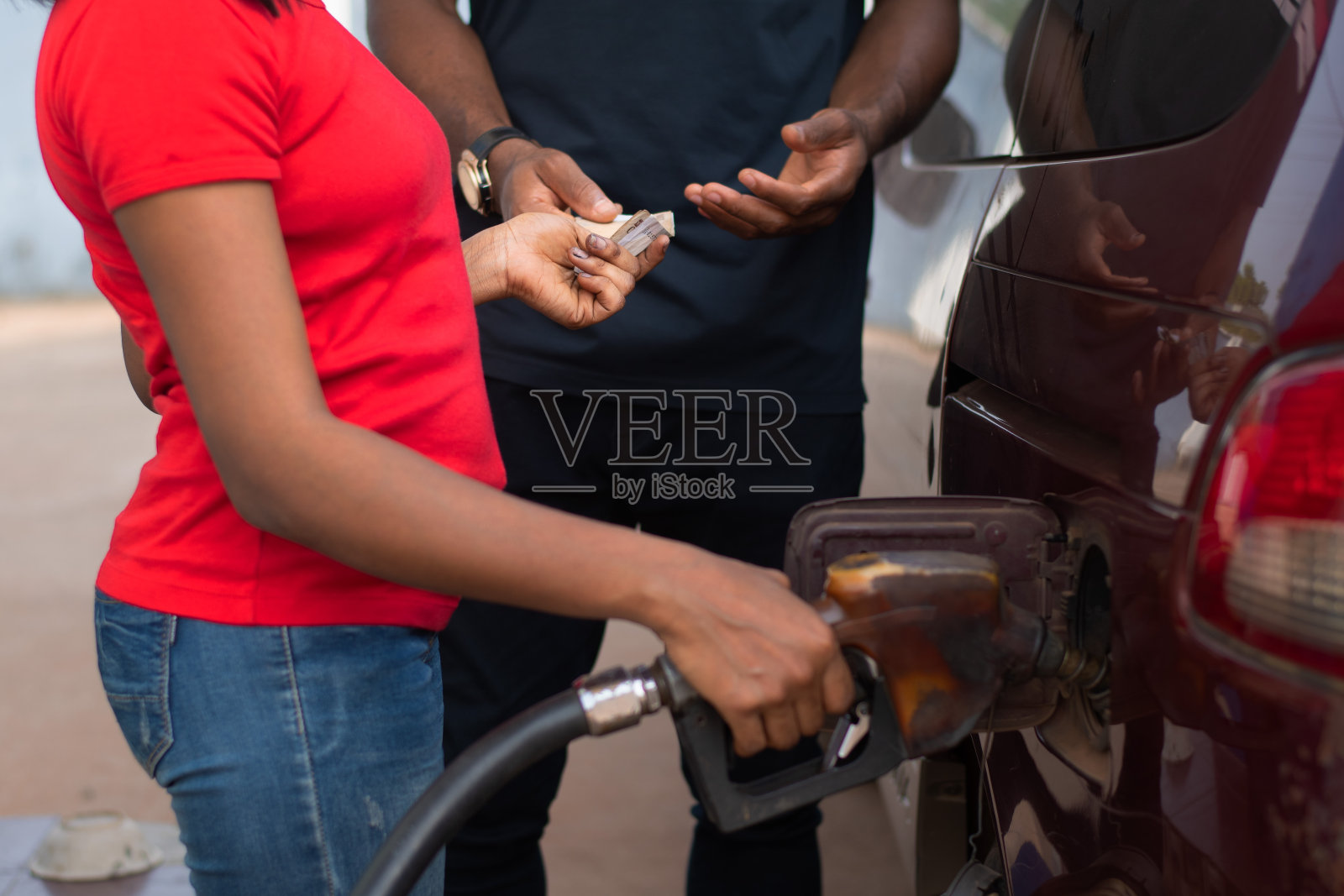 非洲加油站的工作人员拿着钱给车加油照片摄影图片