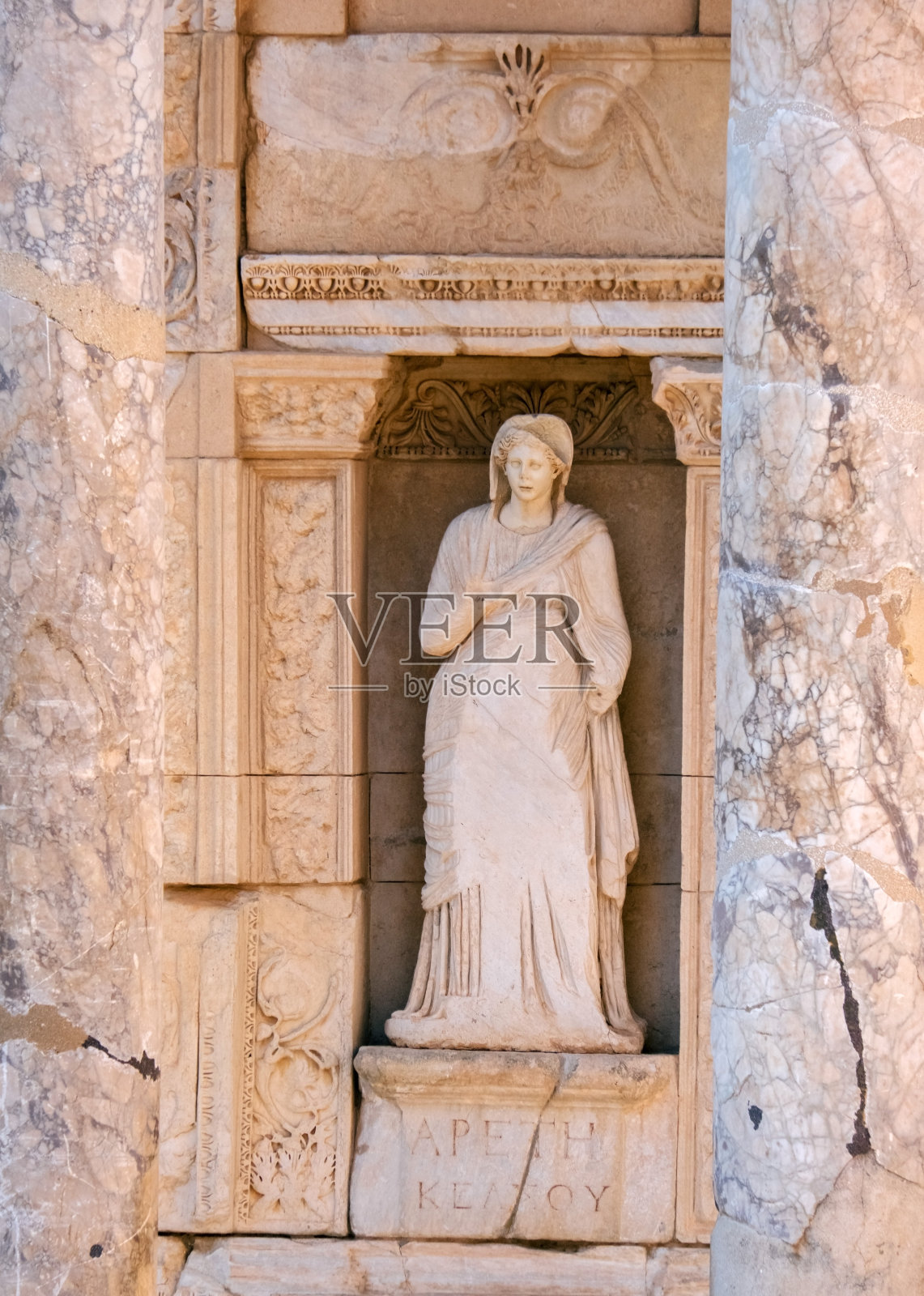 一尊古代穿长袍的女子大理石雕像。以弗所古城塞尔苏斯图书馆的部分外观。照片摄影图片