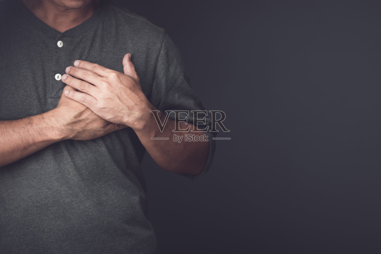 工作时可能发生的伤害或疾病。男子因受伤、疼痛或感觉不舒服而用手捂住左胸。心脏病和保健概念。照片摄影图片