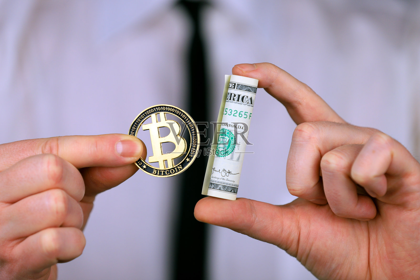 商人手里拿着比特币和一捆美元照片摄影图片
