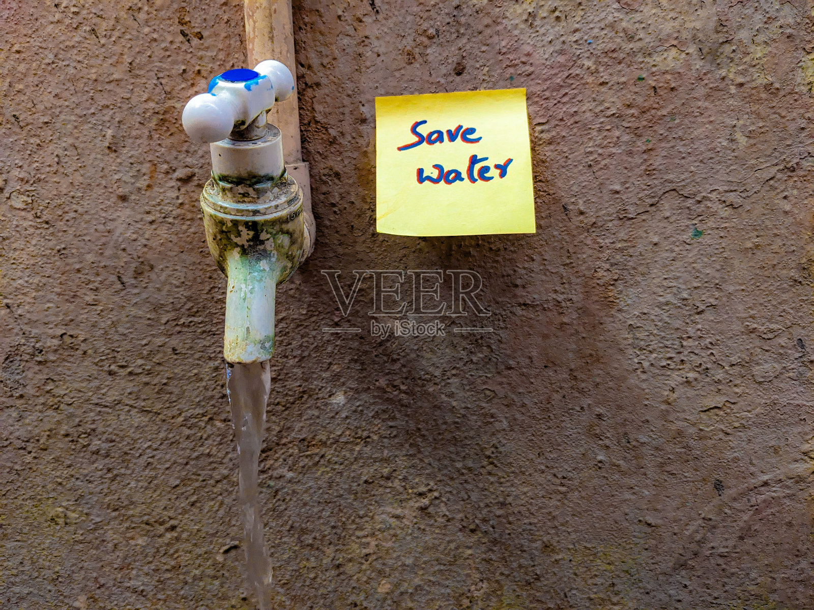 他们把节约用水写在便利贴上，贴在水龙头附近照片摄影图片