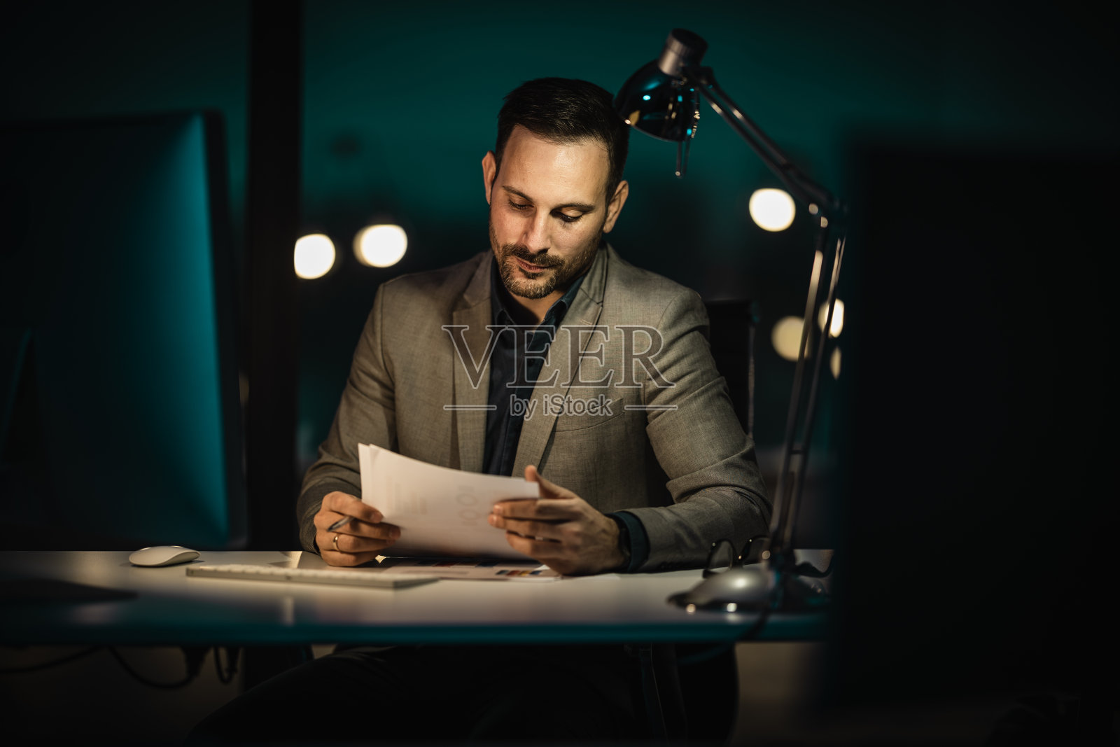 疲惫的年轻人在办公室用电脑工作到深夜的肖像照片摄影图片