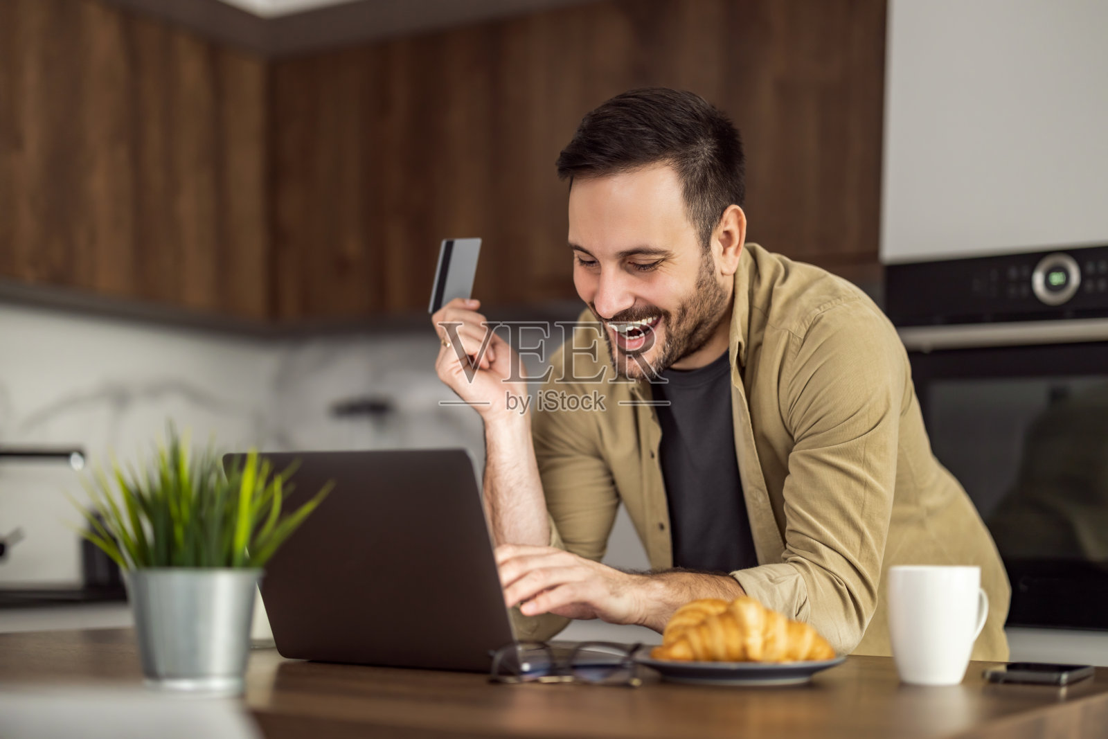 商人使用笔记本电脑和信用卡进行在线支付照片摄影图片