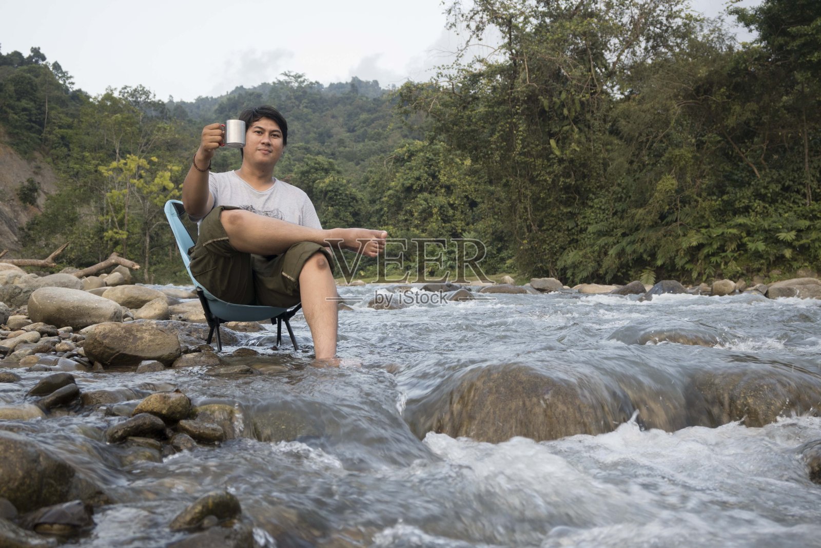 男人在享受咖啡和玩手机时放松-资料图片照片摄影图片