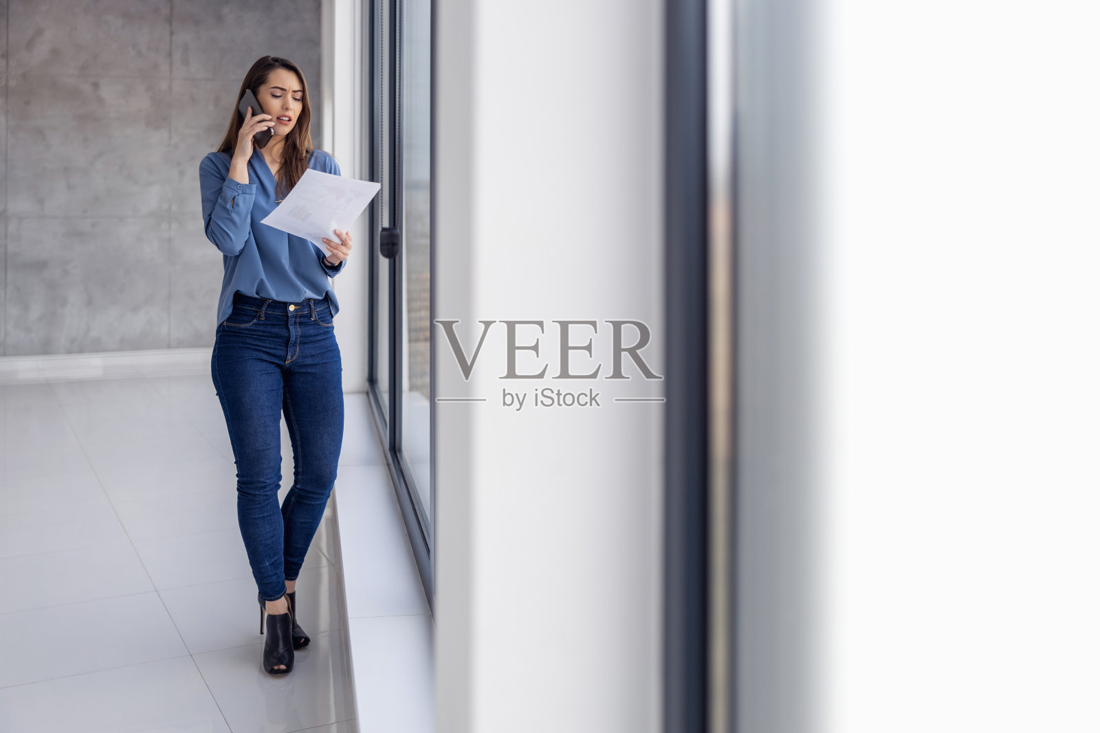 在现代办公室里使用智能手机的严肃女商人照片摄影图片