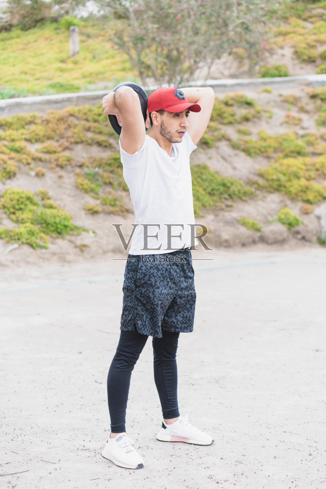 年轻男子在公园做不同的热身和有氧运动与杠铃盘照片摄影图片