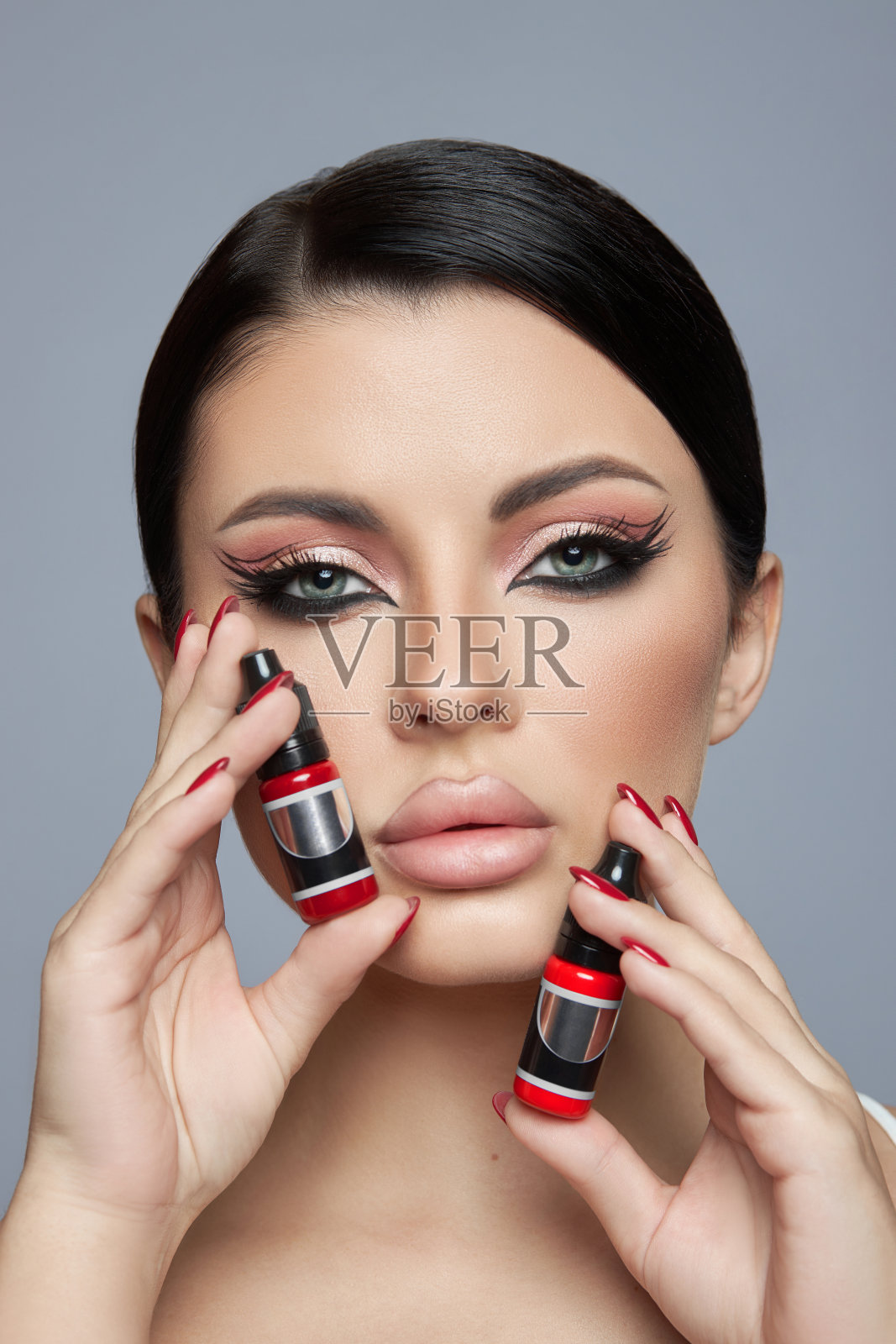 美女肖像，粉色眼影妆，箭头和长睫毛。黑发女人，红色指甲油，天然化妆品照片摄影图片