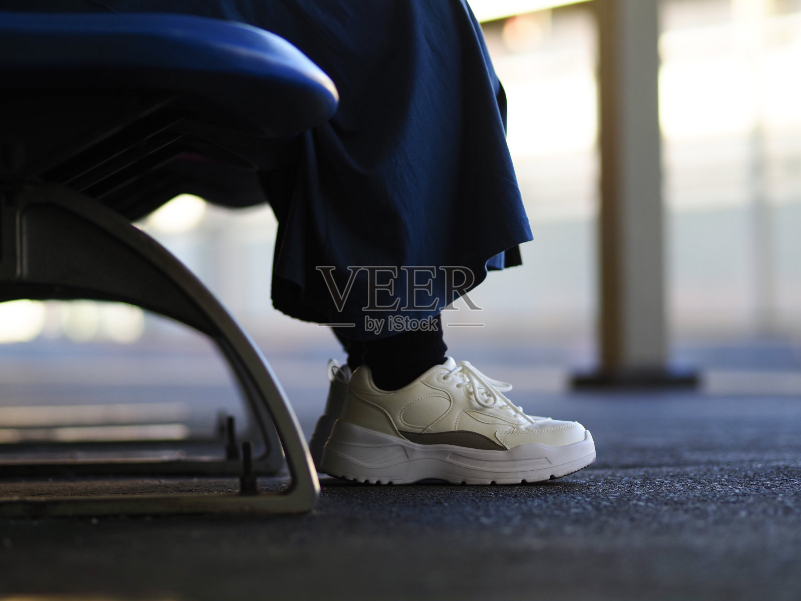 一个女人坐在长凳上的脚照片摄影图片