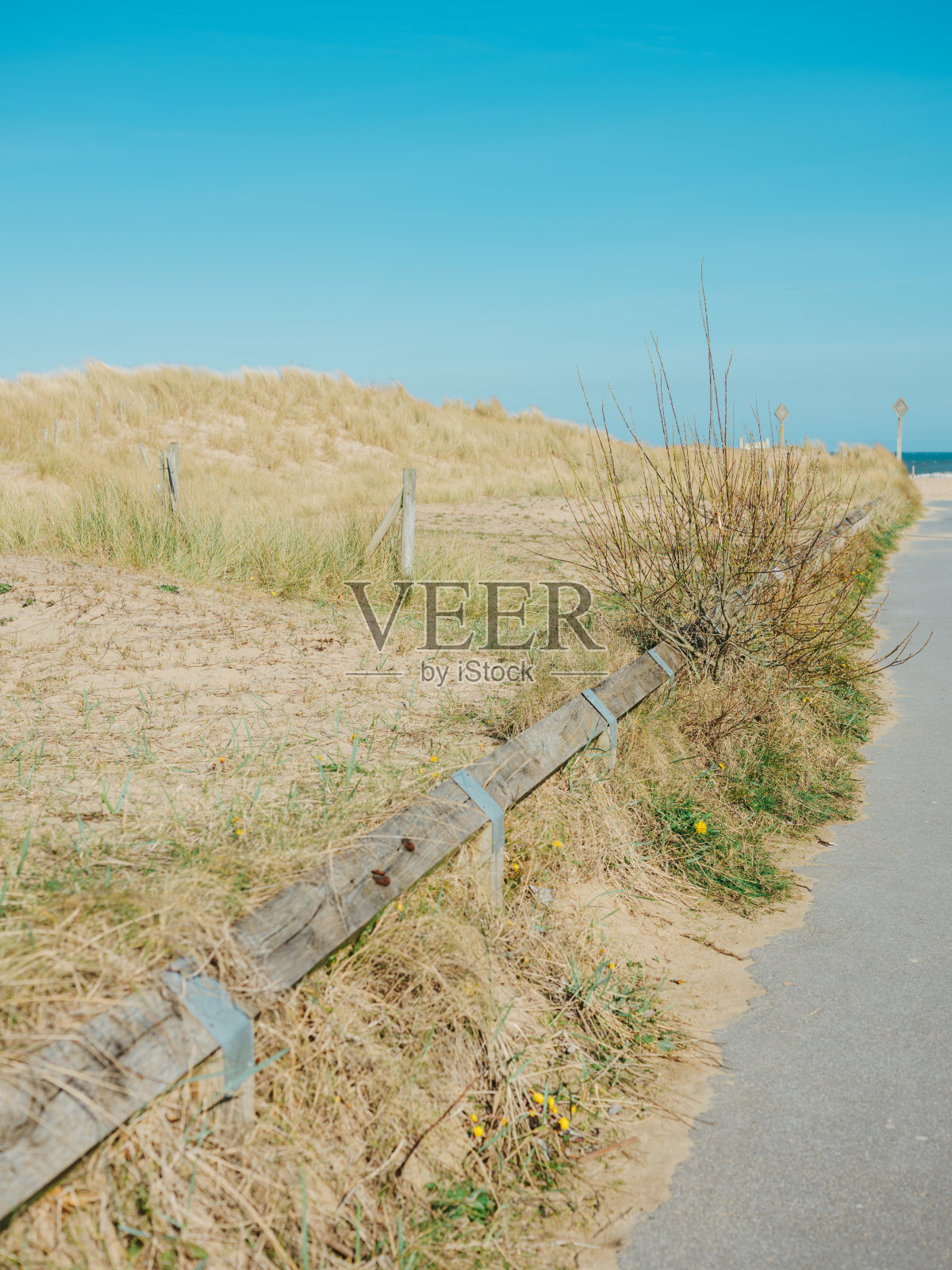 蔚蓝的天空，干枯的草地，沙地上的篱笆照片摄影图片
