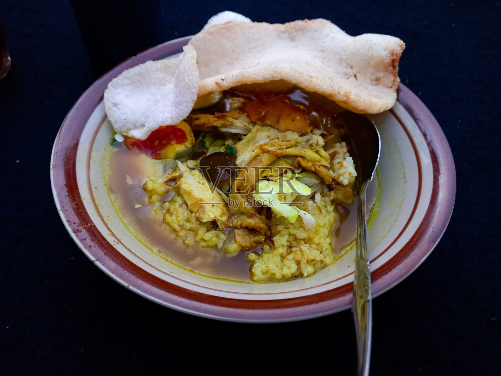 印度尼西亚的索托鸡或索托Ayam鸡。Soto ayam是一道传统的印尼菜，用鸡肉、粉丝、豆芽等食材加入汤中，姜黄为主要原料。照片摄影图片