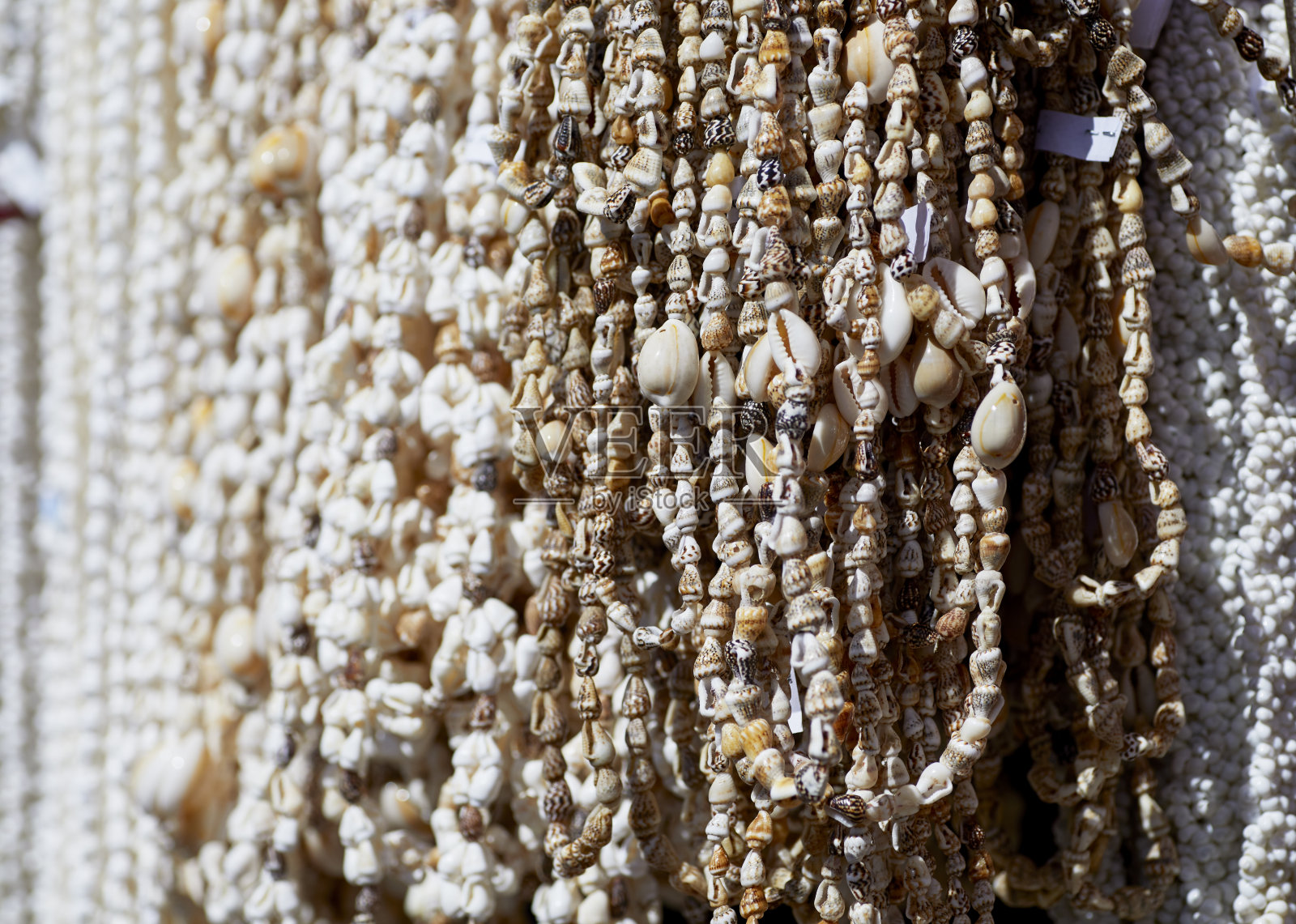 手工制作的彩色贝壳项链挂在架子上照片摄影图片