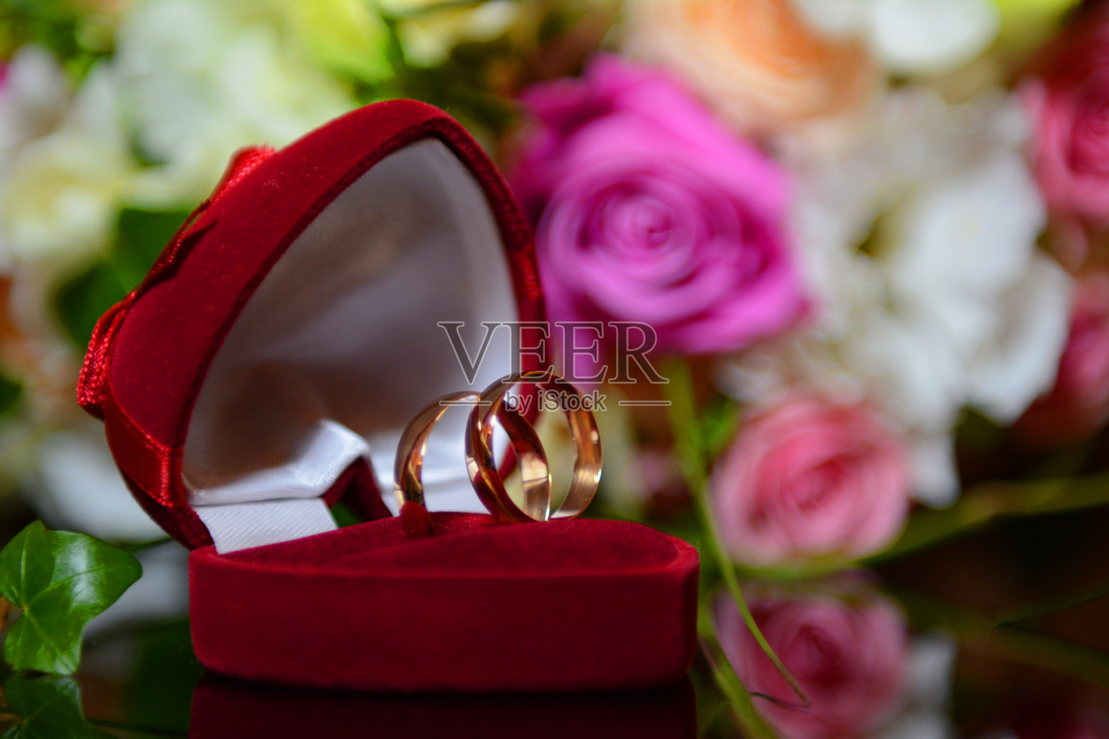 婚礼花束与金结婚戒指在一个黑暗的桌子反射一个美妙的背景为广告沙龙照片摄影图片