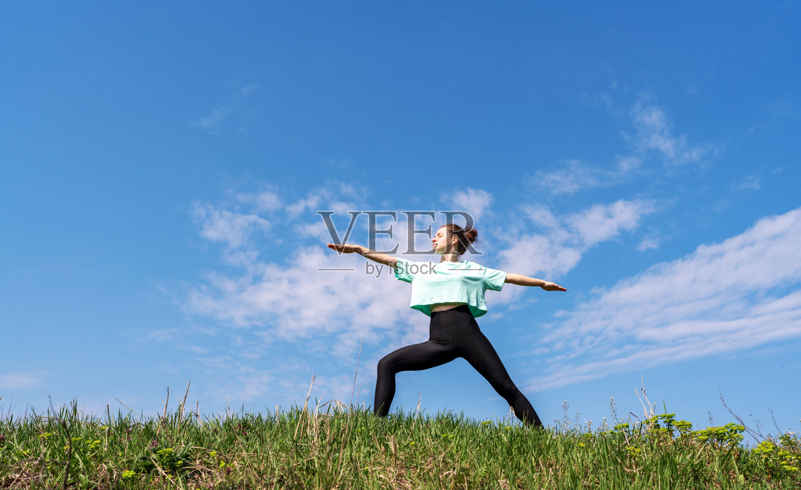 健身女子在户外蓝天下做瑜伽。照片摄影图片