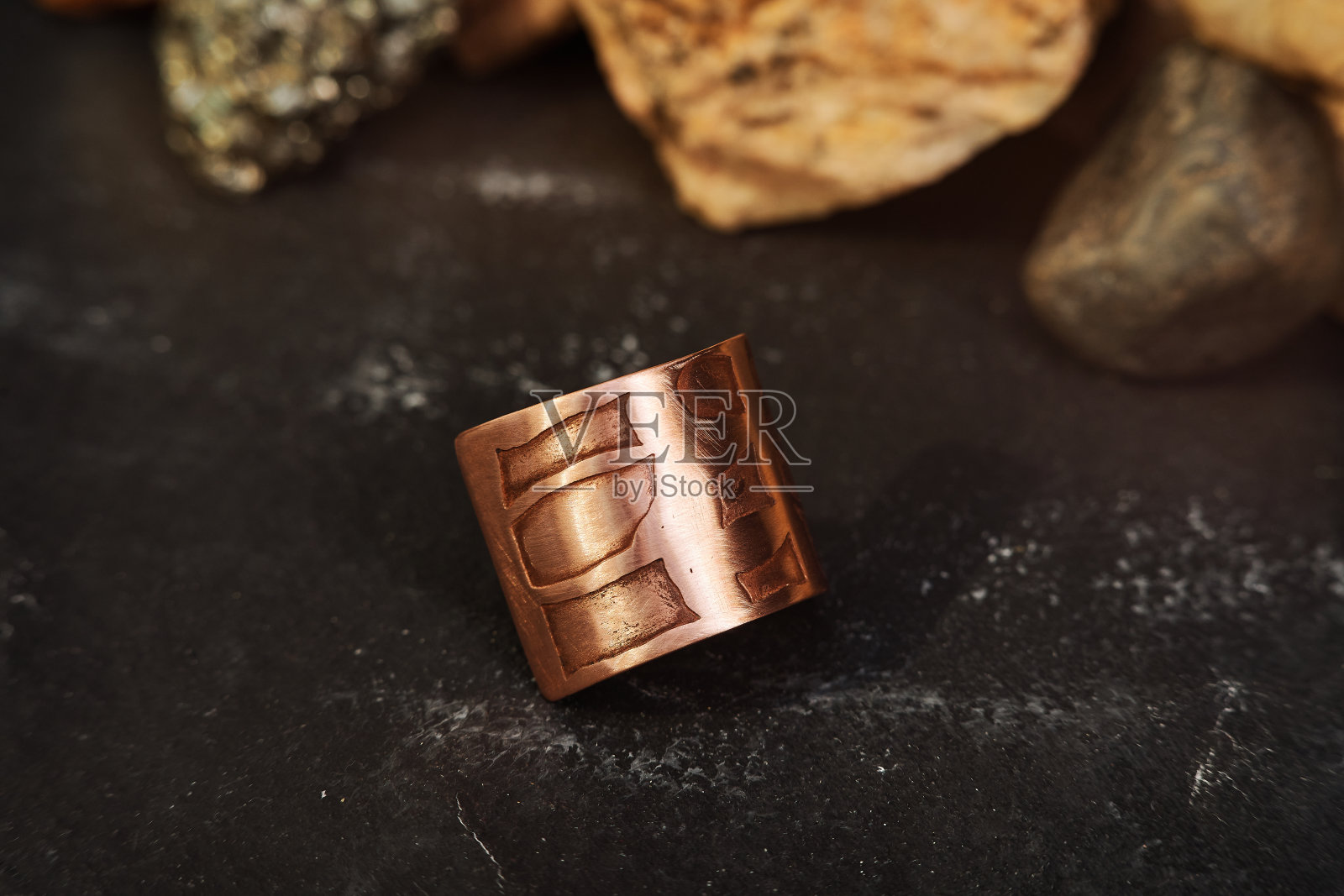 特写镜头手工弯曲矩形熔岩形状铜环黑色背景照片摄影图片