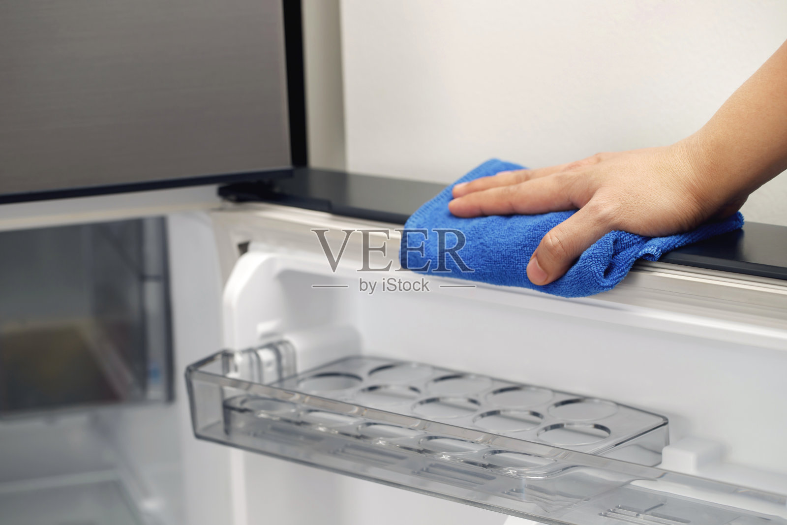 员工们用一块布清洁冰箱。照片摄影图片