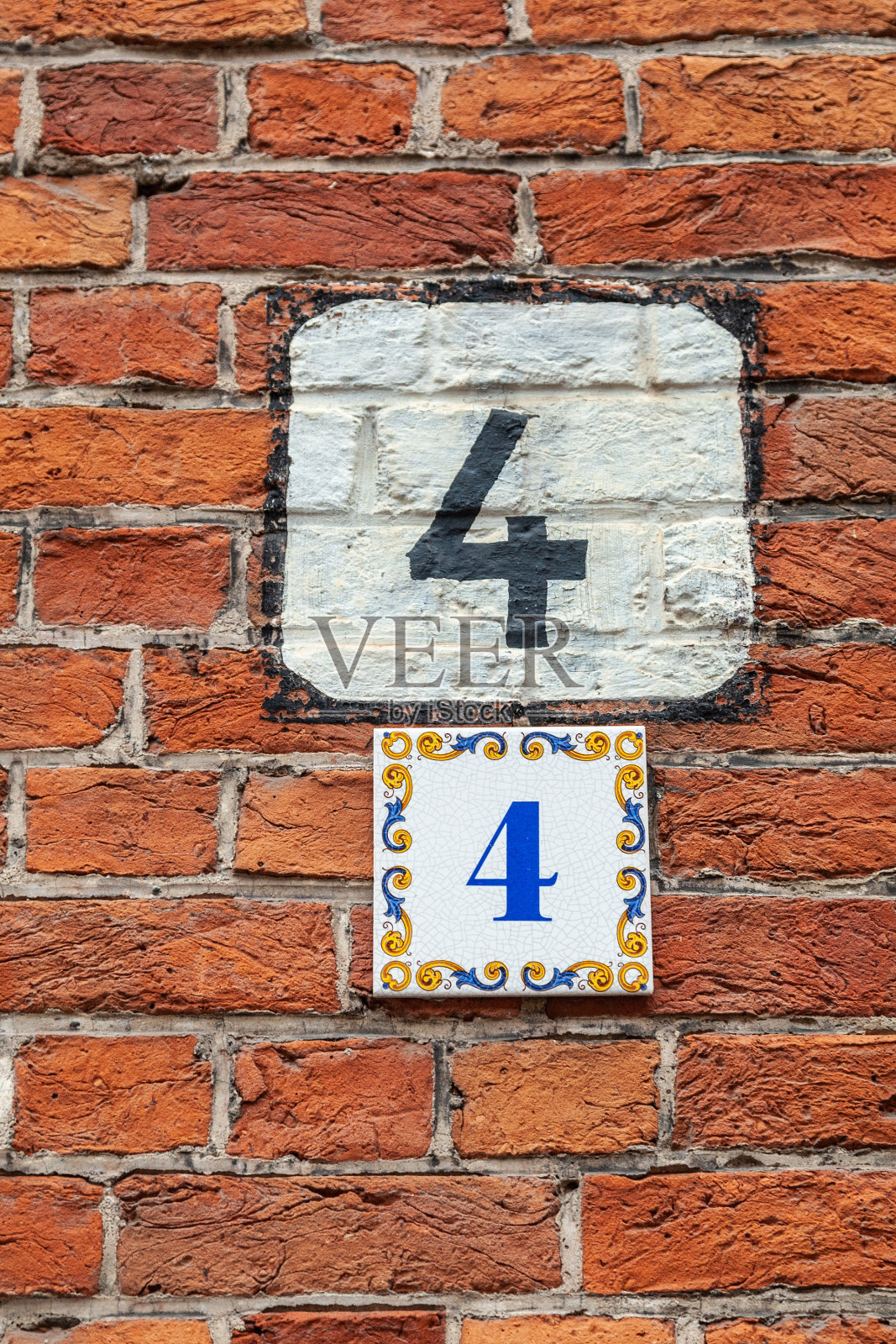 4个数字装饰字体在黑色油漆对白漆盾手绘在房子的墙壁红砖。照片摄影图片