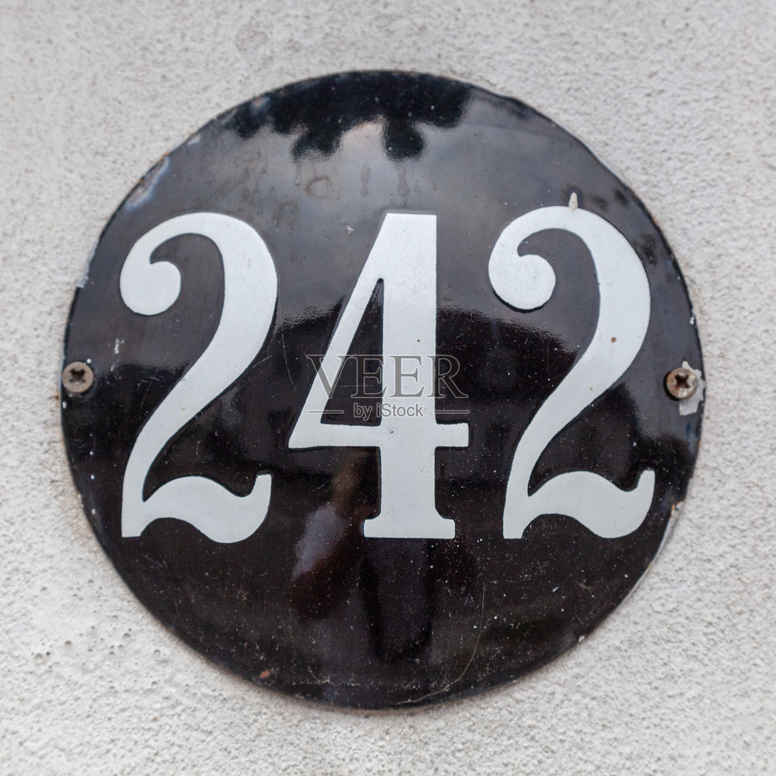 242金属装饰数字牌匾在白色渲染水泥房屋立面。照片摄影图片