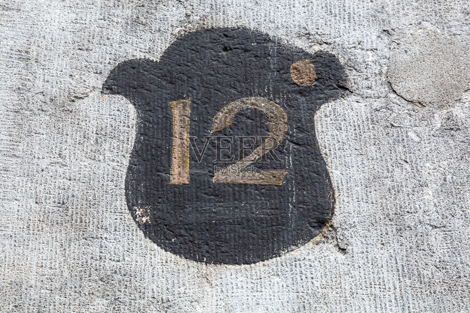 12个数字装饰字体在褪色的金色对黑色油漆盾牌手绘在房子的墙上。照片摄影图片