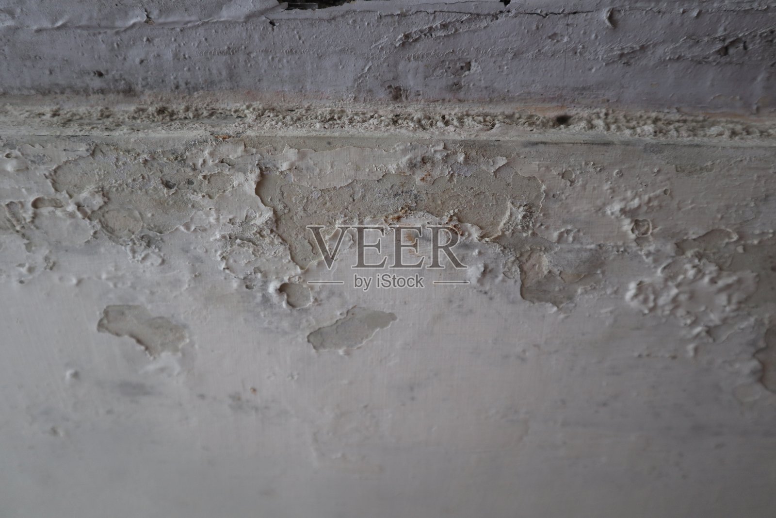 混凝土墙的全景，旧的开裂剥落的油漆。经过风化的粗糙油漆表面，有裂缝和剥落的图案照片摄影图片