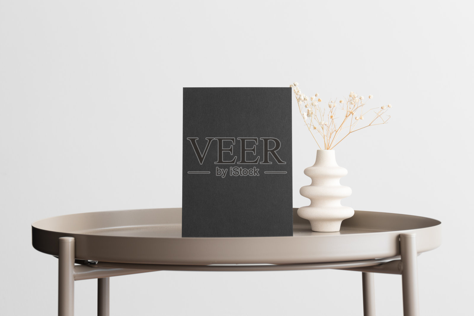 黑色的邀请卡片模型，米色的桌子上有一个gypsophila装饰。5x7的比例，类似于A6, A5。照片摄影图片