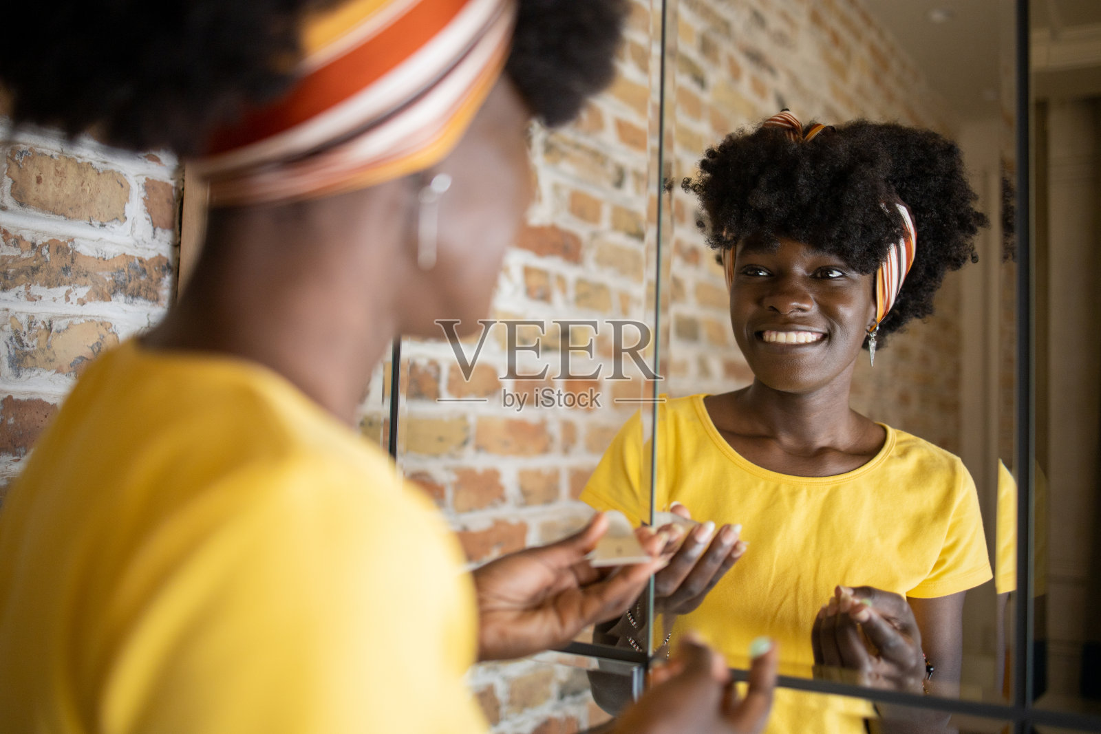 一个漂亮的女人在他脸上涂保湿霜照片摄影图片