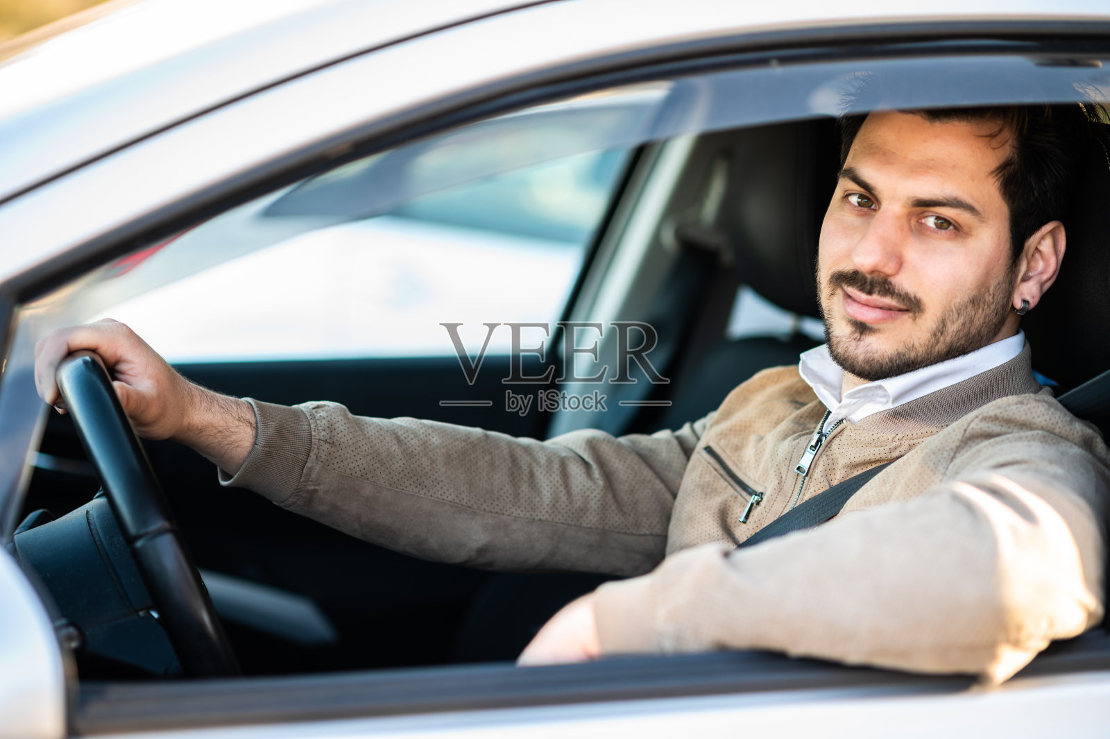 英俊的年轻人在他的车里。照片摄影图片