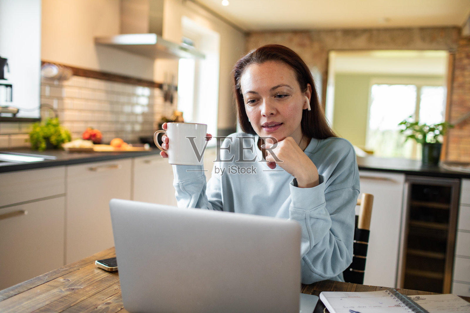 年轻女子在厨房用笔记本电脑工作照片摄影图片