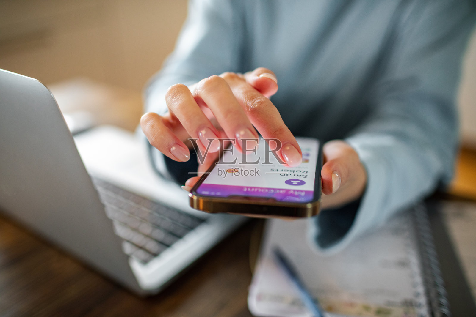 年轻女子在家工作时使用手机上的银行应用程序照片摄影图片