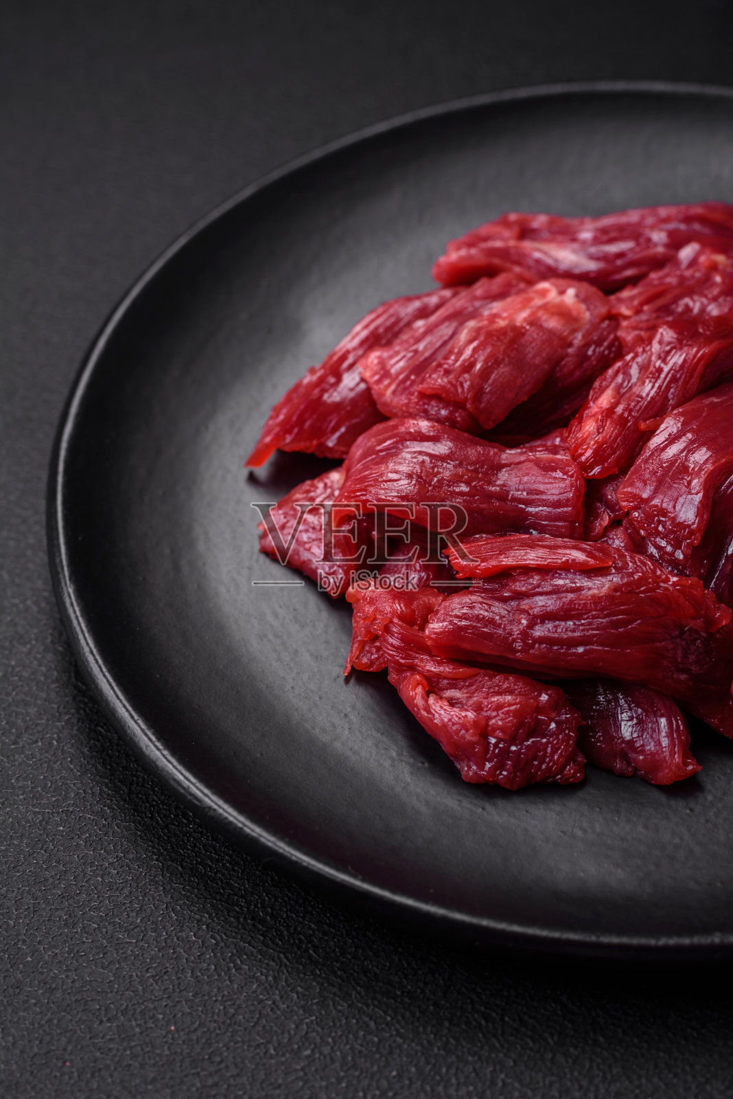 新鲜生牛肉加盐、香料和香草照片摄影图片