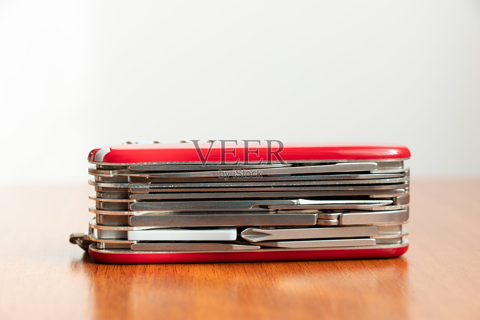 多功能刀放在木桌上，白色背景特写照片摄影图片