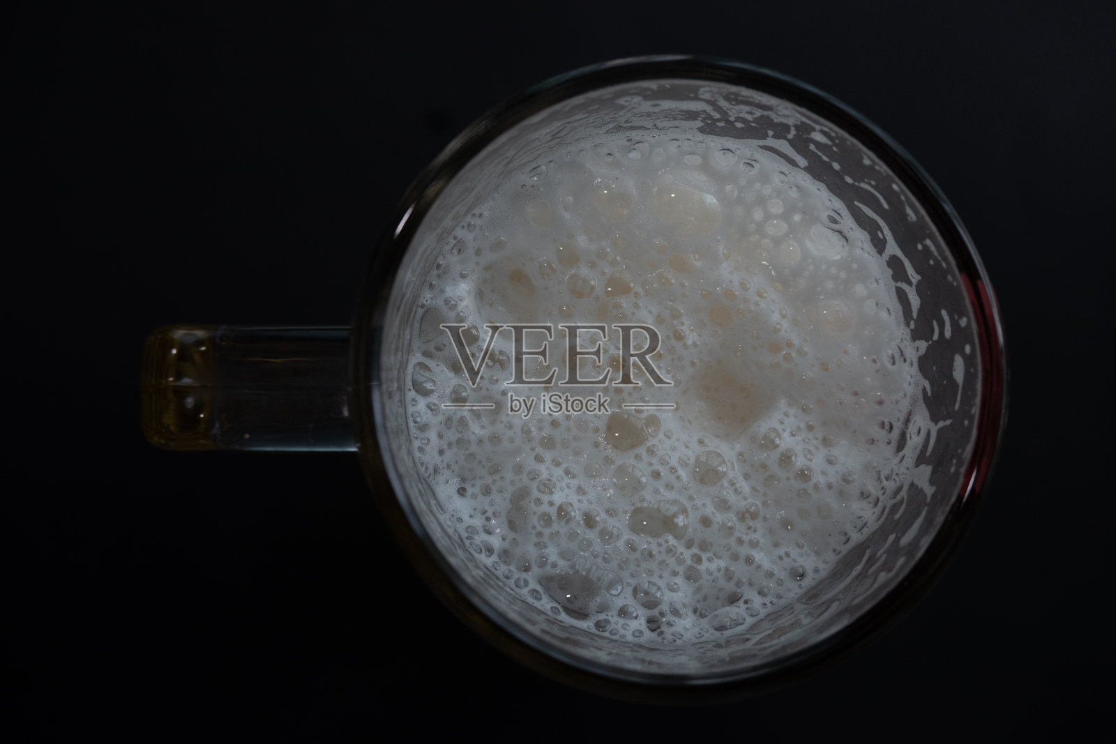 啤酒杯里的白色泡沫。阴影的背景。照片摄影图片