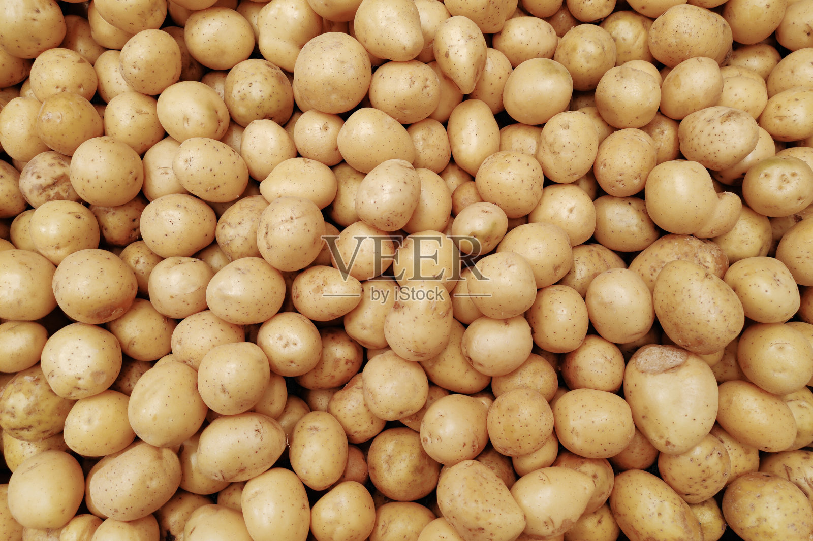 市场柜台上有一大堆土豆。食品的背景。土豆收获概念。照片摄影图片