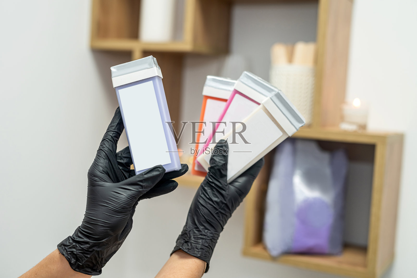 美容师的手拿着脱毛用的脂溶性蜡盒。照片摄影图片