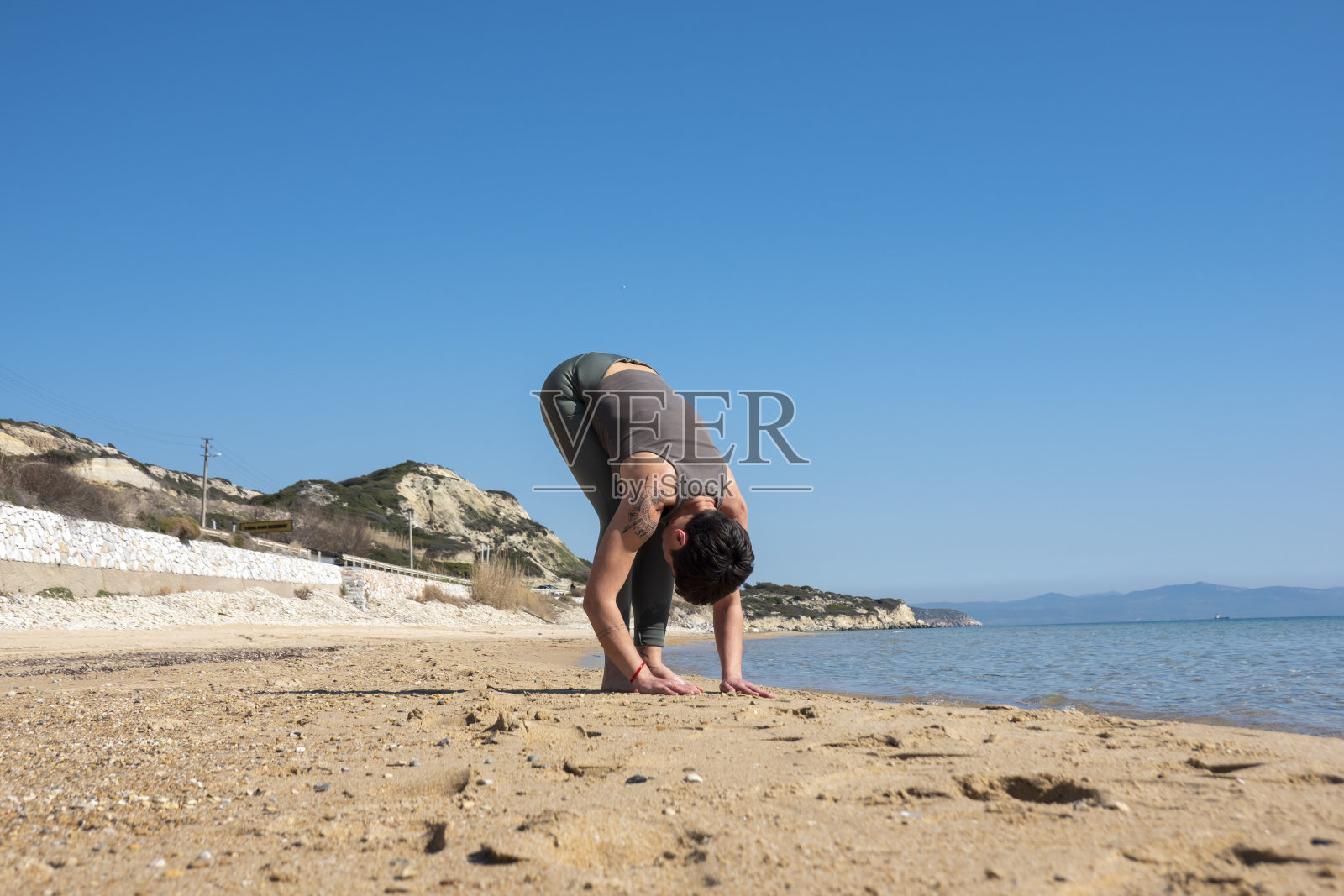 一名女子在海滩上练习瑜伽照片摄影图片