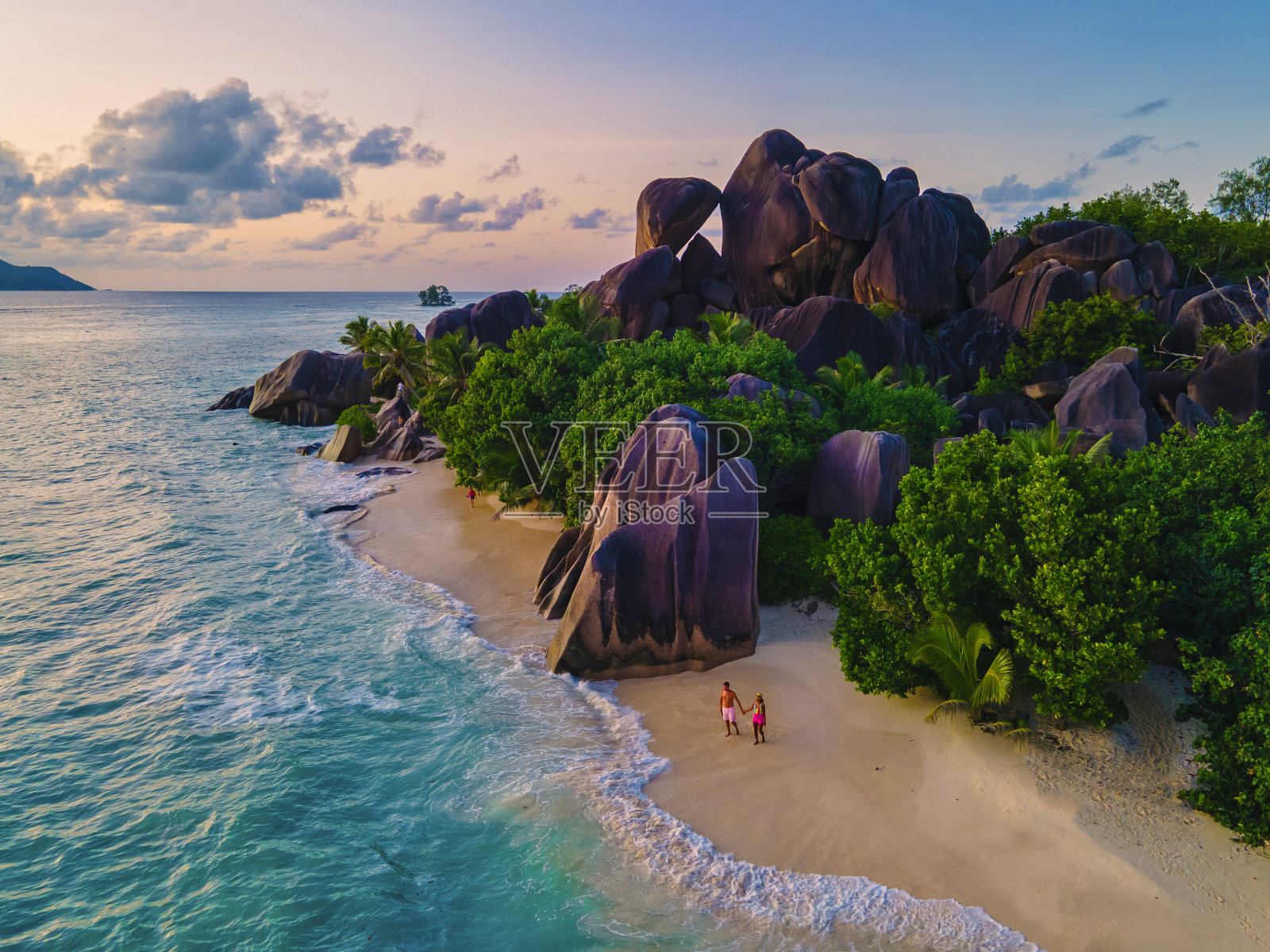 Anse Source d'Argent海滩，拉迪格岛，塞舌尔，无人机鸟瞰拉迪格塞舌尔鸟瞰，一对夫妇在豪华度假的日落时分走在海滩上照片摄影图片