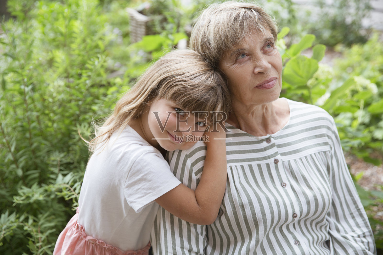 老巫婆和小孙女一起在花园里玩。快乐的家庭在户外享受夏天。照片摄影图片
