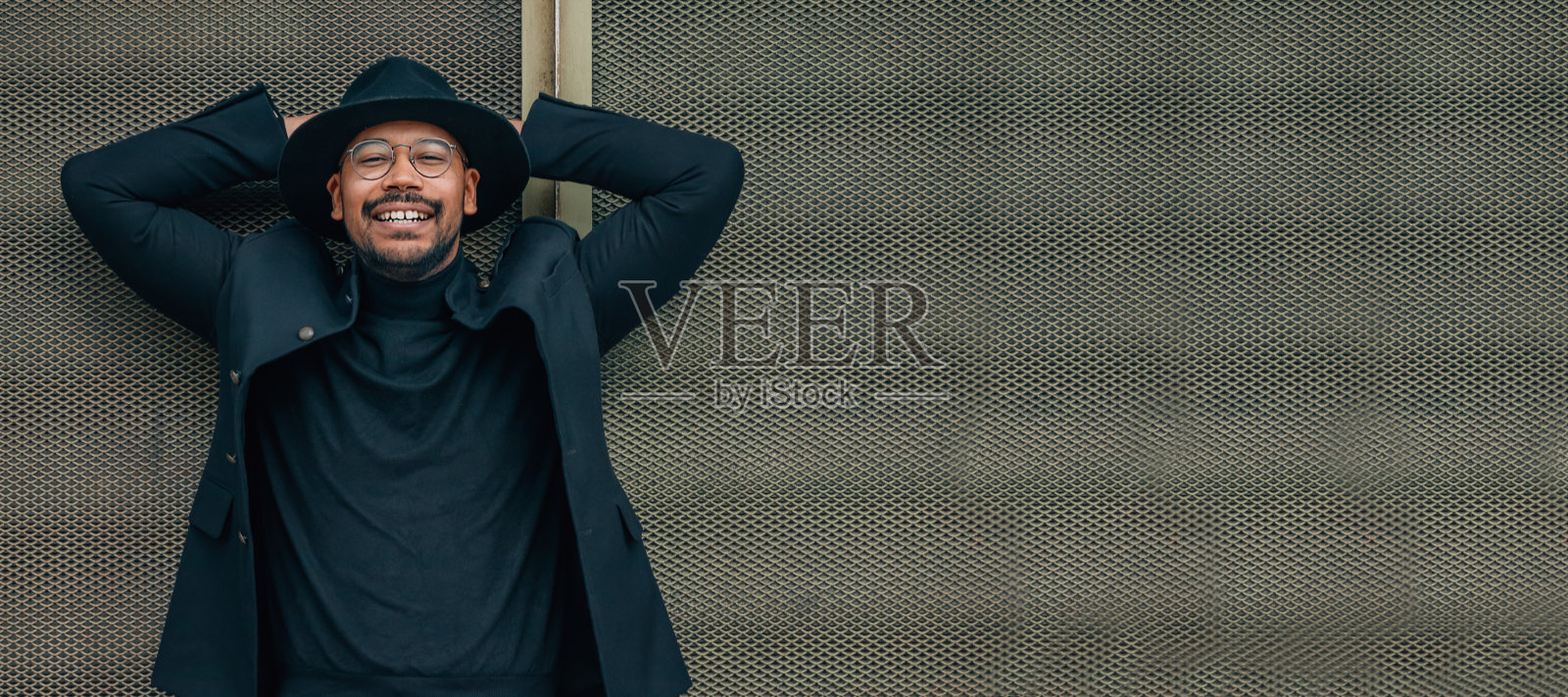 男人在街上靠在墙上放松和快乐照片摄影图片