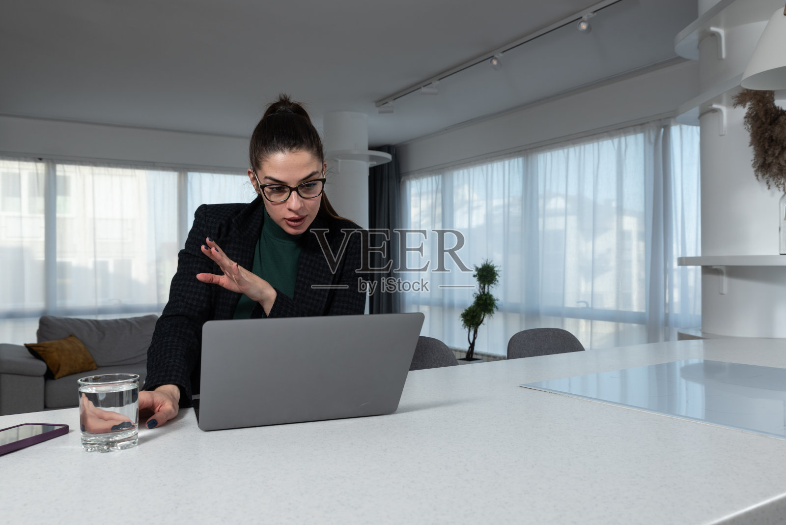 年轻的自由职业者女性婚礼活动策划师和顾问坐在笔记本电脑上工作，为客户提供新的想法，因为她阅读和写她从婚礼计划选项中写的东西照片摄影图片