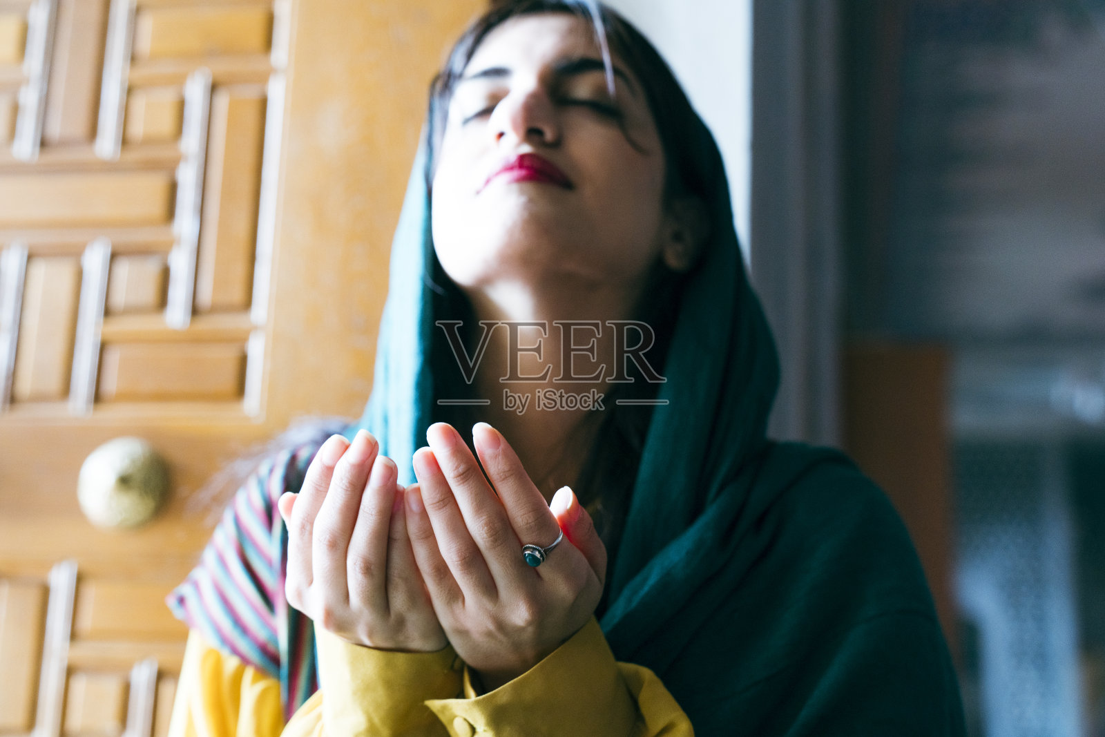 在清真寺里，戴着头巾和面纱的穆斯林妇女举起双手祈祷，宗教祈祷概念照片摄影图片