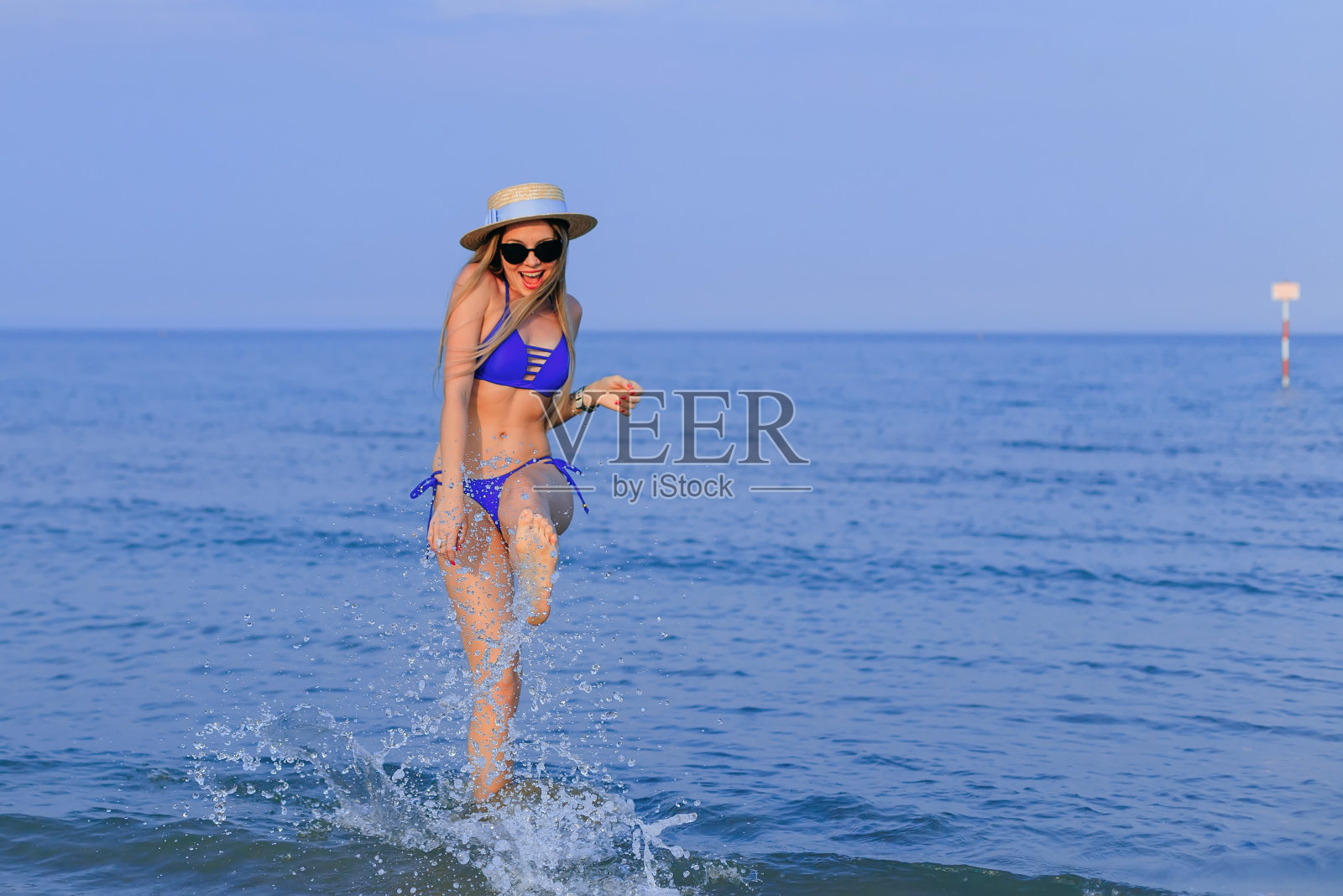 穿着蓝色泳装的女孩度过了一个愉快的暑假照片摄影图片