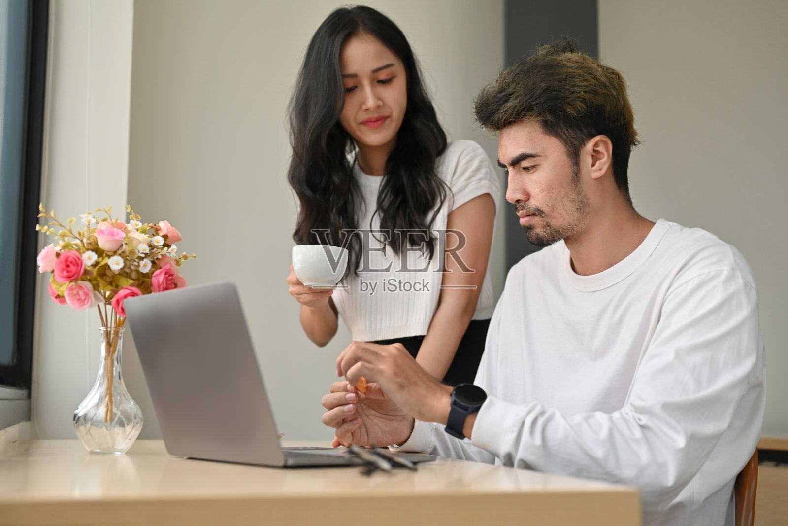 两位自由职业者在联合办公空间里一起使用笔记本电脑工作。照片摄影图片